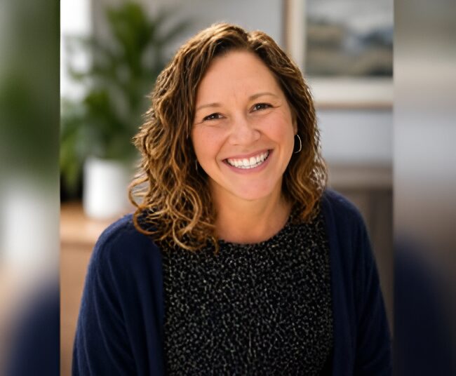 Smiling woman with curly hair indoors.